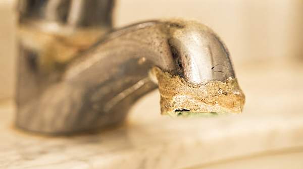 Editorial illustration for How Hard Water Damages Your Appliances and Plumbing—and the Signs to Check For